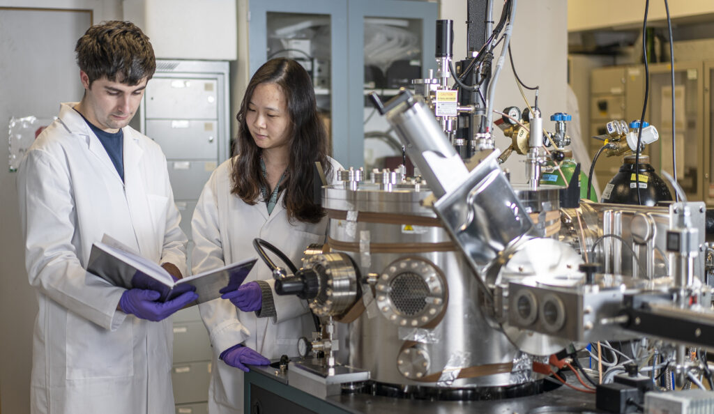 Two researchers working at Royce Cambridge's Physical Vapour Deposition and Characterisation Facility